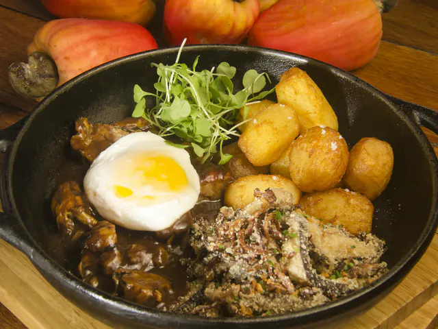 Côte de noix de cajou avec farofa de merde, pomme de terre rouge et oeuf