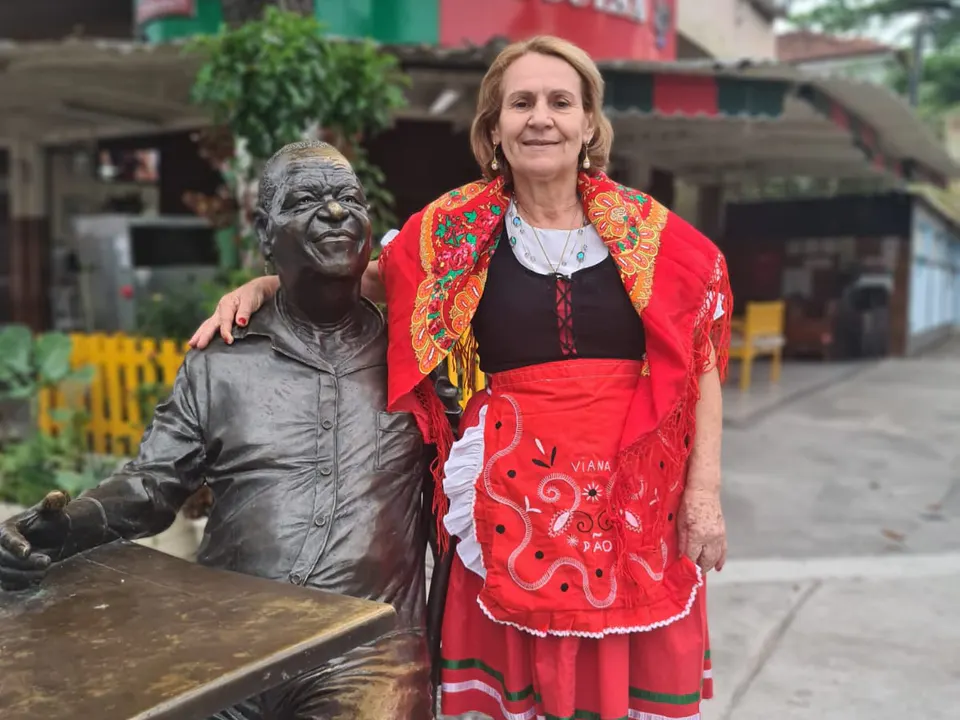 Donzília Gomes neben der Statue von Pixinguinha, die in den 1960er Jahren die Bar da Portuguesa besuchte.
