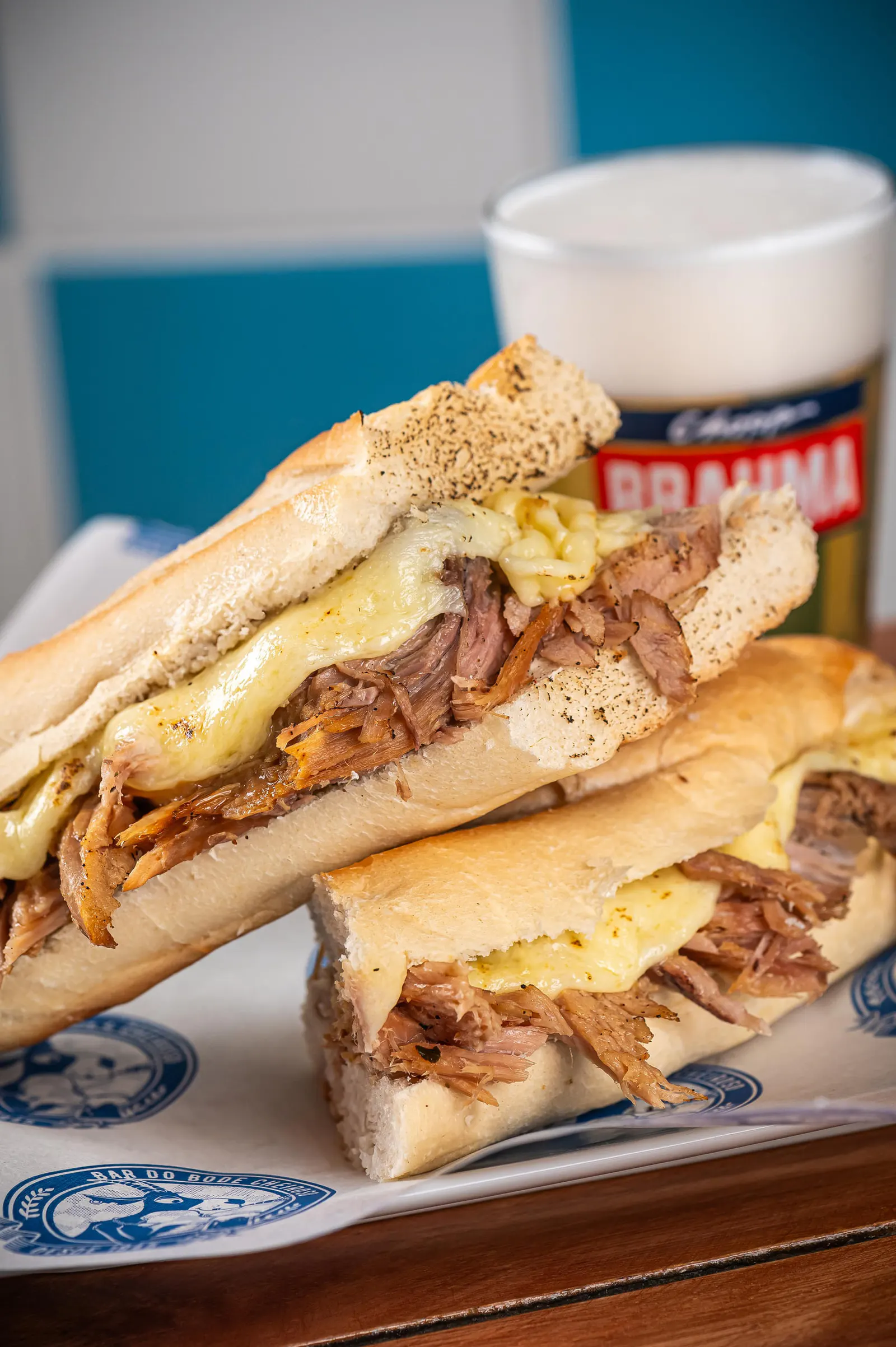 Sanduíche de Pernil con Provolone: Sanduiche de pernil con provolone gratinado, salsa de piña y acompañamiento de fritas.
