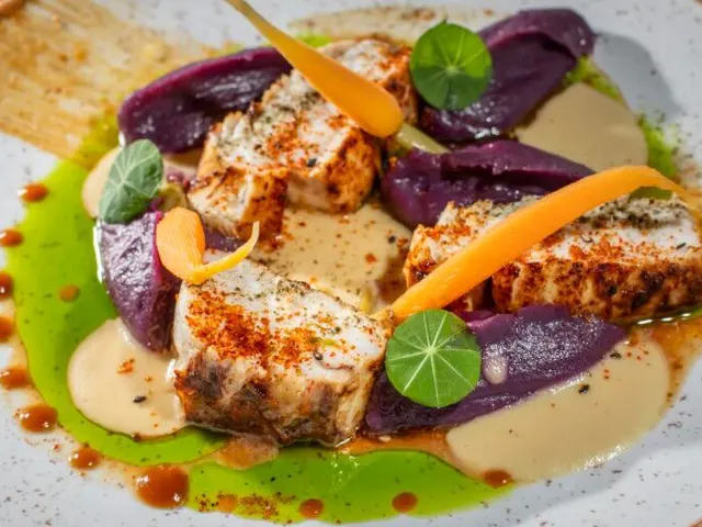 Frischer Bass begleitet von Purpurpüree, organischen Mini-Karotten und einem zarten Beurre Blanc de Wasabi. Ausrüstung mit Pulver