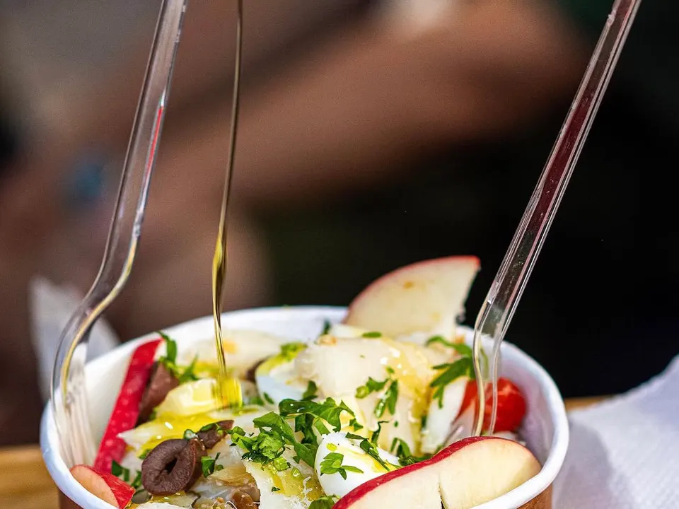 Salada de Bacalhau: Deliciosa ensalada servida con granos de bico y lascas de bacalao acompañada de huevos, aceitunas, salsa