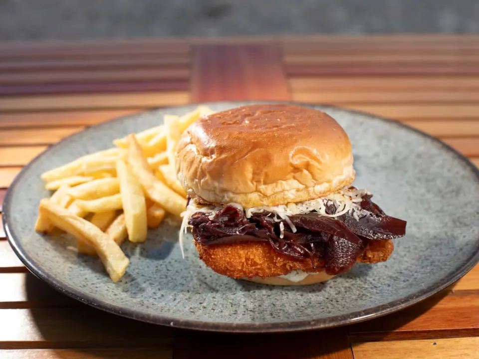 Fischfilets, gefüllt mit panko, mit lila Zwiebel Chutney, Ranch-Sauce und Käse, serviert auf weichem Briochebrot.
