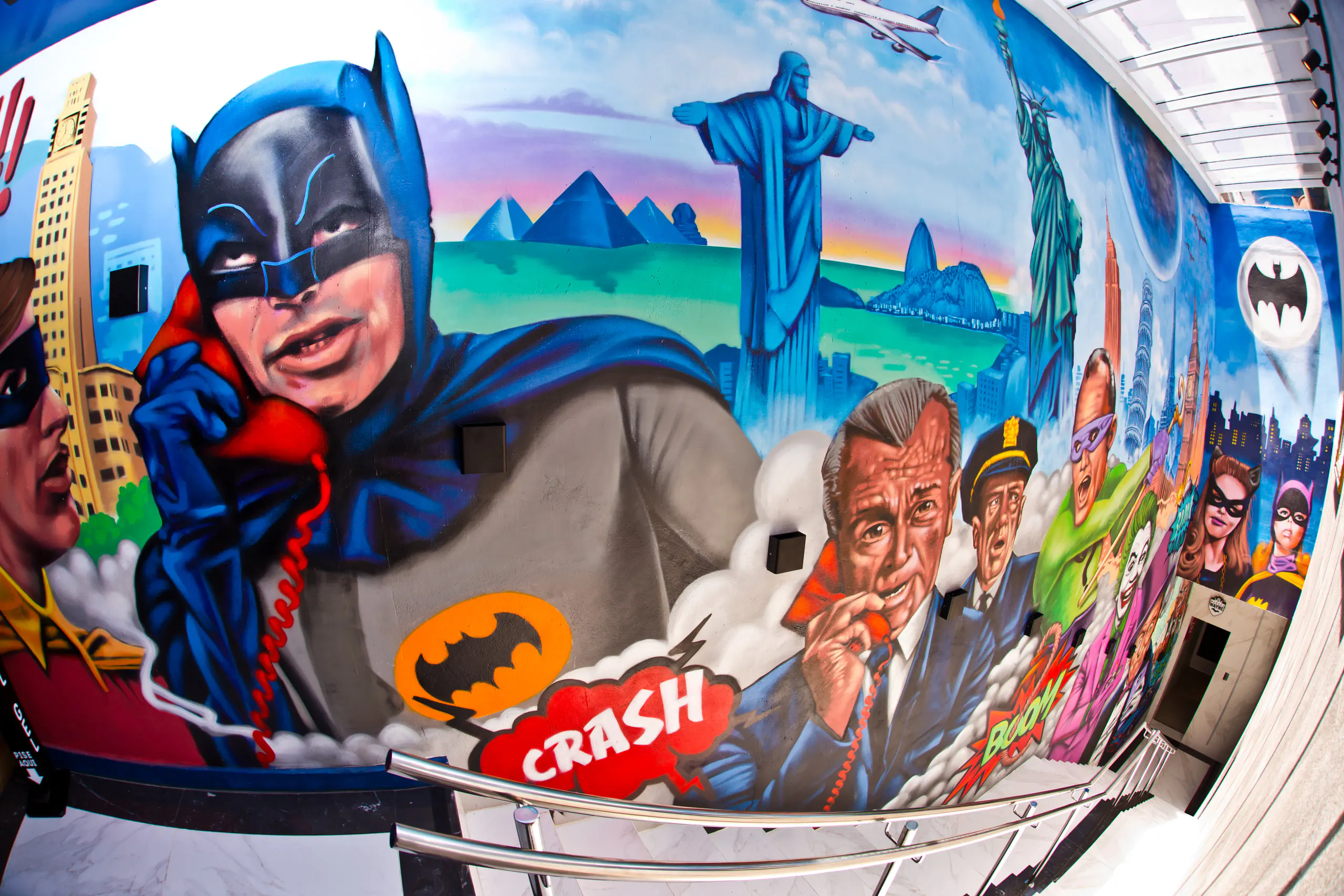 Colored ladder wall with Batman on the phone, the Cristo Redentor, the Pão de Açúcar and other serial characters painted on the wall.