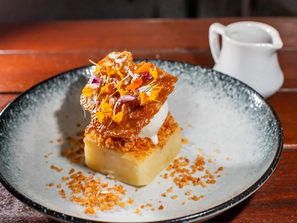 Weicher Aipimkuchen, serviert mit cremigem Käsegelato und süßem Milchsirup. Ein unwiderstehliches Dessert, das mischt